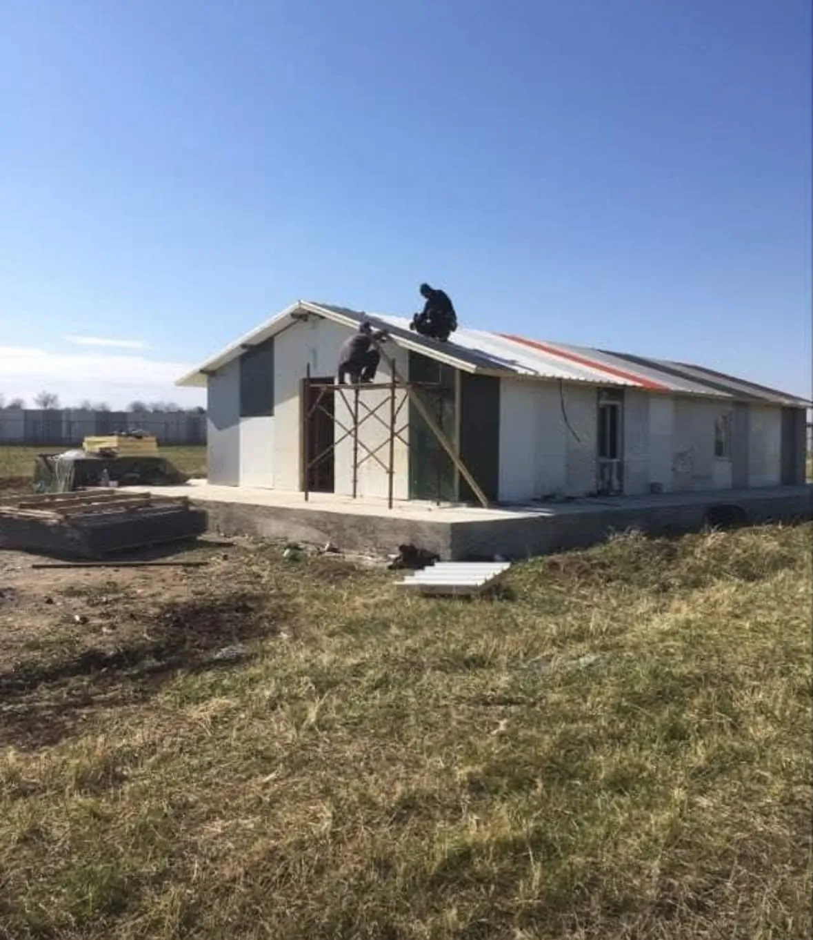 A helper on the roof of the new building.