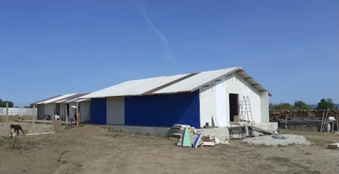 The finished blue and white building under a clear sky.